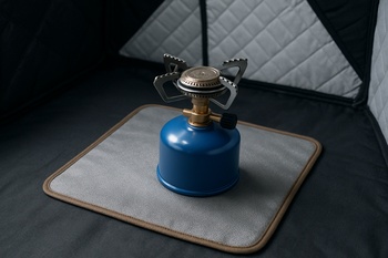 Compact heater standing on a metal pad inside a shelter