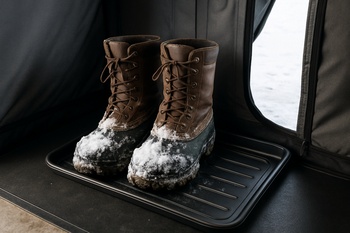 Boot tray with wet boots placed near the shelter door