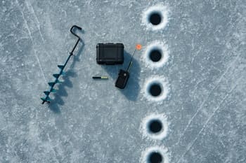 Overhead line of drilled holes stretching across a frozen bay